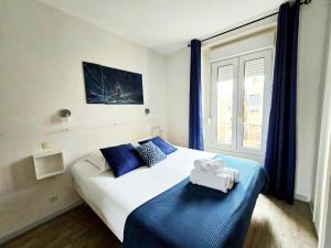 una camera da letto con un letto con asciugamani sopra di LAYTON - A 2 min de la plage, du sillon et d'Intra muros ! a Saint Malo Altre 10 foto