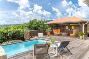 a backyard with a pool and a gazebo at Villa Vue Mer, piscine, proche de la plage et Golf Trois Ilets in Les Trois-Îlets