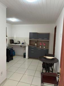 a kitchen with a table and a kitchen with a counter at Departamento portal de ferradura in Búzios