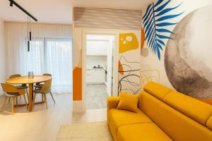 een woonkamer met een gele bank en een tafel bij Smart Serendipity Apartments in Boekarest