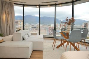 a living room with white furniture and a table with a view at Rooftop Tirana in Tirana