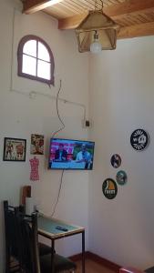 a room with a table and a tv on a wall at Departamento 1 in Comodoro Rivadavia
