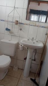 a bathroom with a toilet and a sink at Departamento 1 in Comodoro Rivadavia