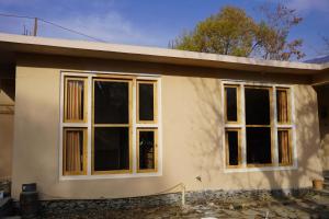 una casa con ventanas en un lateral en Secret Garden Hostel & Guesthouse, en Chitral