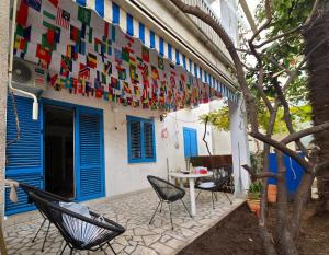 a patio with chairs and flags hanging from a building at Hostel Budva in Budva