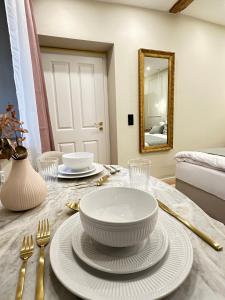 een tafel met een kom, borden en een spiegel bij Fewo Sand 10 - klein in Bamberg