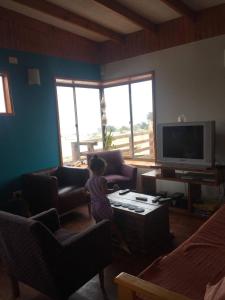 Ein kleines Mädchen steht im Wohnzimmer in der Unterkunft Cabaña Las Cruces in Las Cruces