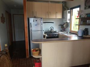 eine Küche mit einem weißen Kühlschrank und einer Theke in der Unterkunft Cabaña Las Cruces in Las Cruces + 3 Fotos