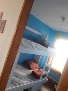 2 Etagenbetten in einem Zimmer mit blauen Wänden in der Unterkunft Cabaña Las Cruces in Las Cruces