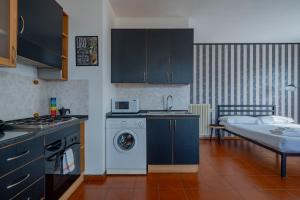 VISTA LAGO DI COMO - Suite con Wifi e Parcheggio في Fiumelatte: مطبخ مع حوض وغسالة ملابس
