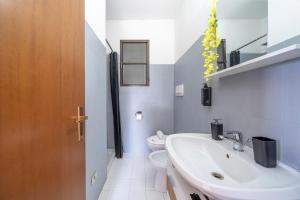 VISTA LAGO DI COMO - Suite con Wifi e Parcheggio في Fiumelatte: حمام مع حوض غسيل أبيض ومرحاض