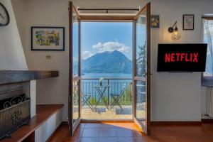 VISTA LAGO DI COMO - Suite con Wifi e Parcheggio في Fiumelatte: باب على شرفة مطلة على جبل