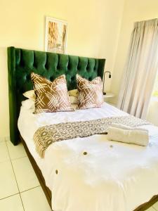 a large bed with a green headboard in a room at The Beacon Fairy in East London