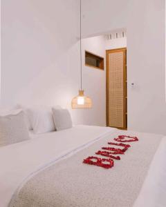 a white bed with red napkins on it at 2BR Private Pool Beach Villa Near Sanur & Ubud in Ketewel +23 photos
