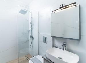 a white bathroom with a sink and a shower at Villa Melora in Pitsidia +36 photos