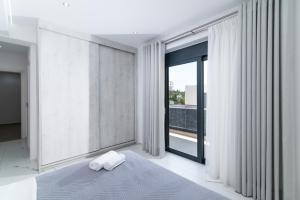 a bedroom with a bed and a large window at Villa Melora in Pitsidia