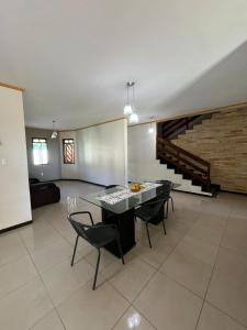 un soggiorno con tavolo, sedie e scala di Chácara com piscina e 3 varandas no Caldas a Barbalha
