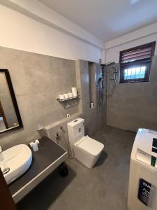 a bathroom with a toilet and a sink and a shower at Ceylon Villa in Matara