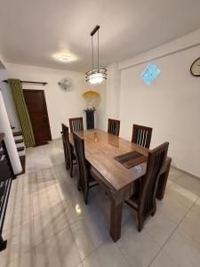 a dining room with a wooden table and chairs at Ceylon Villa in Matara