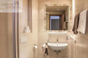 un baño con lavabo y espejo en Alpenperle, en Ischgl 27 fotos más