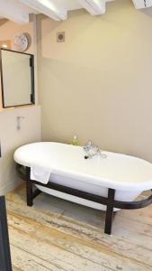 Un lavabo blanco en un baño con espejo. en La Nuit - Suite avec baignoire, en Nantes 10 fotos más