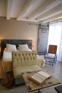 Un dormitorio con una cama, un sofá y una mesa. en La Nuit - Suite avec baignoire, en Nantes