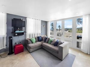 Una sala de estar con un sofá y un televisor. en Villa Capitán Modern Stay Near Beach with pool, en Vega Alta