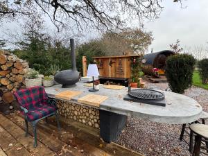 Acorn Hideaway في كانتربيري: طاولة حجرية مع مدفأة في حديقة