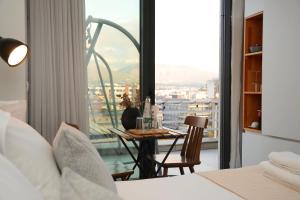 a bedroom with a table and a view of a city at Rooftop Tirana in Tirana