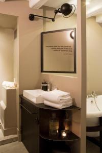 Un baño con lavabo y encimera con toallas. en La Nuit - Suite avec baignoire, en Nantes