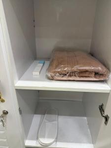 Eine braune Papiertüte steht auf einem Regal im Kleiderschrank. in der Unterkunft PrimeLuxe Stay by Lavishhub in Abu Dhabi