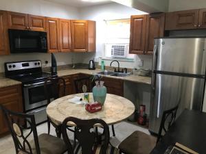 a kitchen with a table and a refrigerator at PalmBeachDowntownPrivatHouseShare99perpersonupto5Party in West Palm Beach