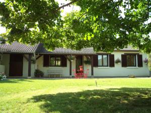 "Chambre familiale", La Maison des Grenouilles في Férolles: منزل أبيض مع كرسي احمر في الفناء