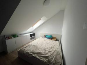 een witte slaapkamer met een bed op de zolder bij Oławska 1A mieszkanie in Środa Śląska