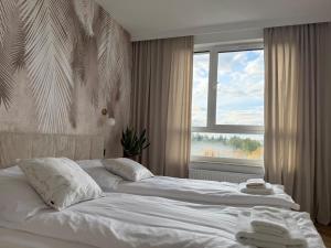 a bedroom with two beds in front of a window at Jarzebinowa Loft III by JumpInHere in Nowy Dwór Mazowiecki