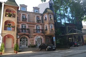 a black car parked in front of a building at Guest House Villa Lord in Novi Sad