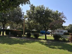 a park with trees and a car parked in a parking lot at Camping des Favards in Violès