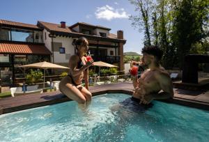 a man and a woman sitting in a swimming pool at Hotel Cuevas - Adults Only in Santillana del Mar +35 photos