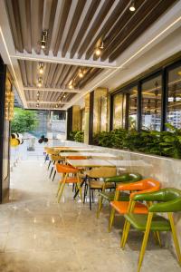 a restaurant with wooden tables and green chairs at Alya Hotel & Suites Ltd in Nairobi