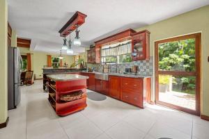 Serenity Villa - 3bd by ZenBreak في سانت بيتير: مطبخ كبير مع دواليب خشبية ونافذة كبيرة