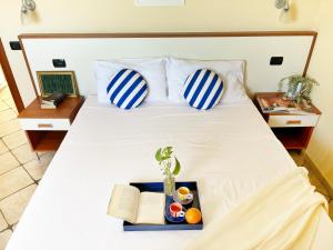 een bed met twee kussens en een dienblad met een plant erop bij Holihome Vascello A7 in Tortoreto Lido