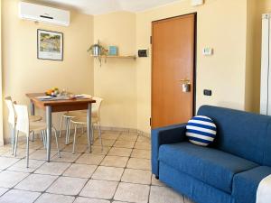 een woonkamer met een blauwe bank en een tafel bij Holihome Vascello A7 in Tortoreto Lido +35 foto's