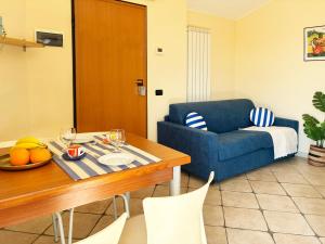 een woonkamer met een tafel en een blauwe bank bij Holihome Vascello A7 in Tortoreto Lido
