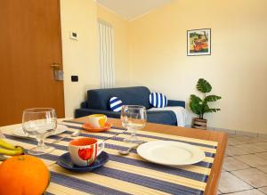 een tafel met borden en glazen erop bij Holihome Vascello A7 in Tortoreto Lido