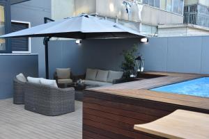 a patio with an umbrella and a swimming pool at 137 LuxResidence in Lisbon