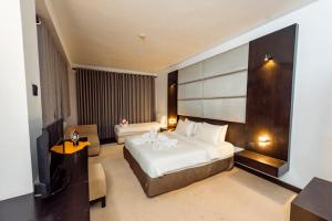 a bedroom with a large white bed in a room at Peacock Beach Resort- Hambantota in Hambantota +8 photos