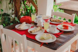 a wooden table with plates of food on it at Pousada Atlantis in Jericoacoara