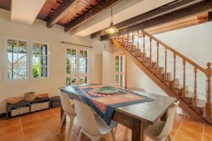 a dining room with a wooden table and chairs at Flora Garden House by HR Madeira in Estreito da Calheta