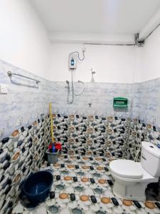 a bathroom with a toilet and a tiled floor at Villa lovely birds mirissa in Mirissa