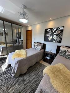 una camera con due letti e un grande specchio di Charmoso apt Milao c garagem no centro a Serra Negra